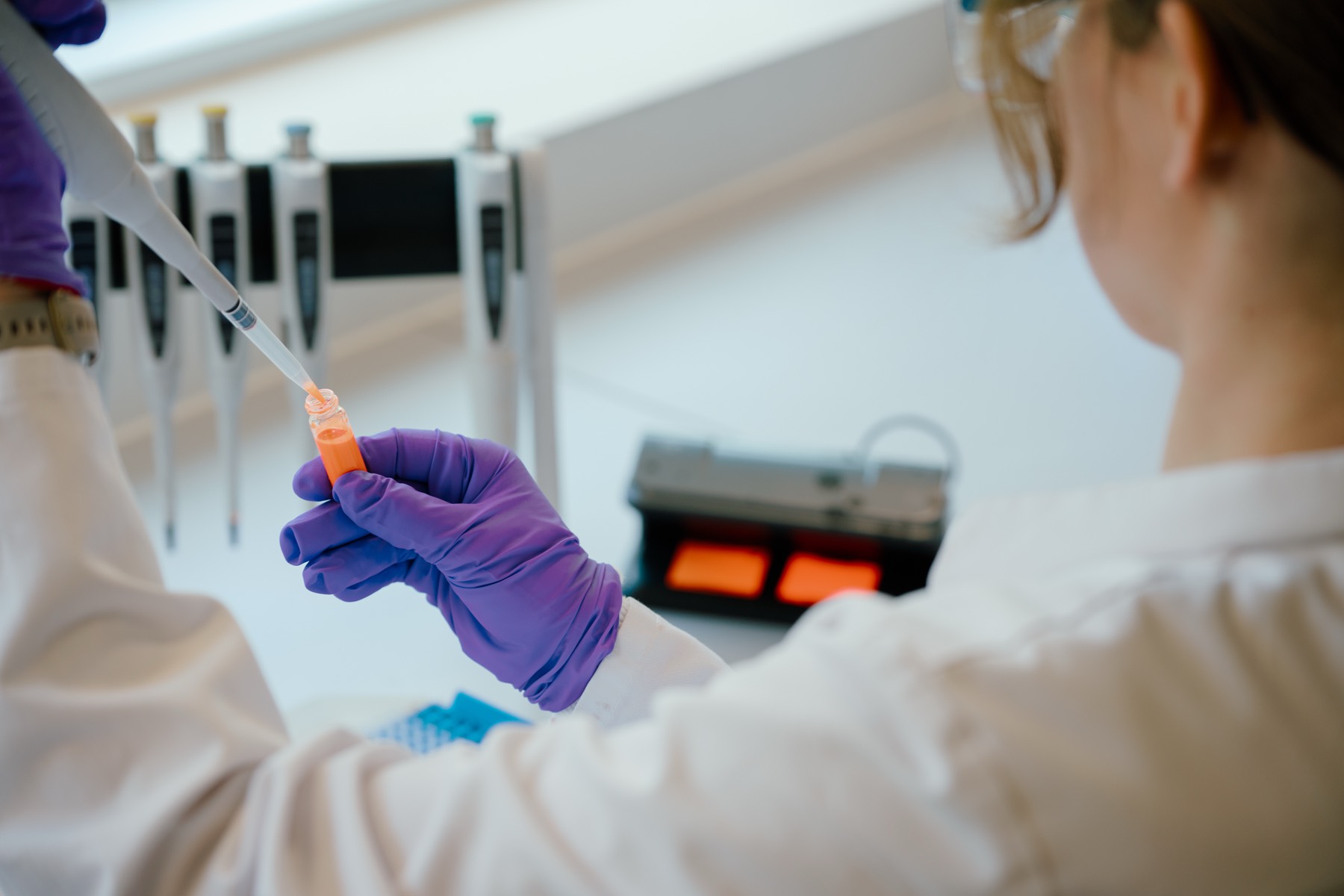 Scientist pipetting QustomJet™ quantum dot ink